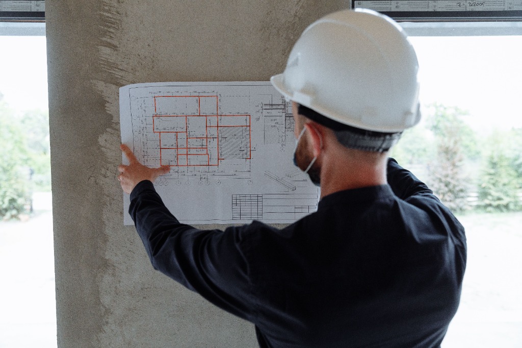 Engenheiro analisando projeto técnico no canteiro de obras